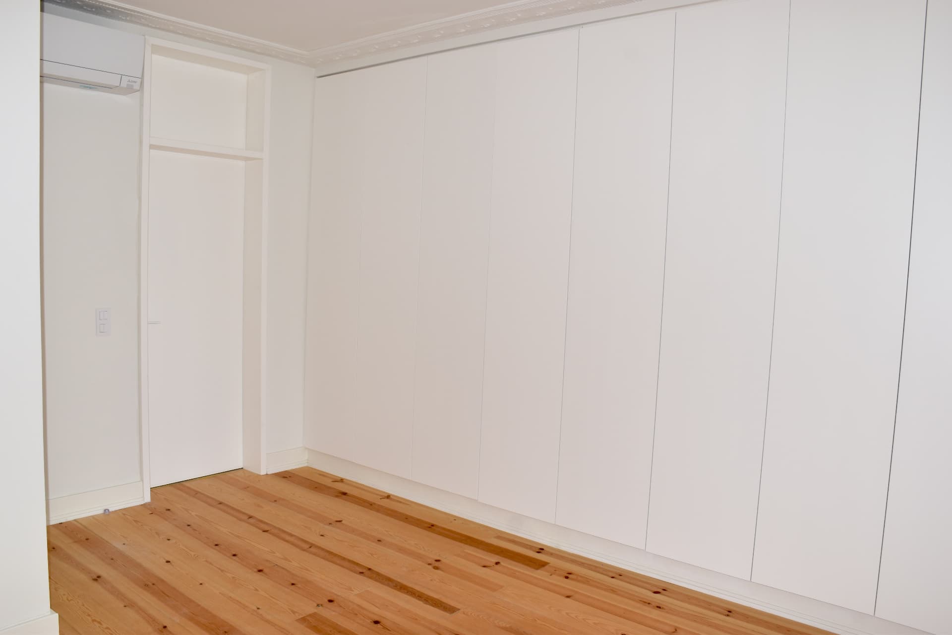 Quarto com parede completa de roupeiros embutidos e ar condicionado