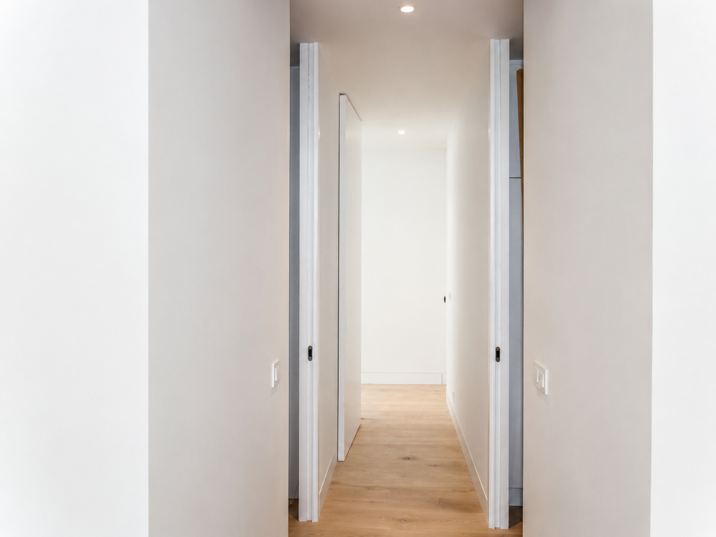 Corredor branco com várias portas interiores