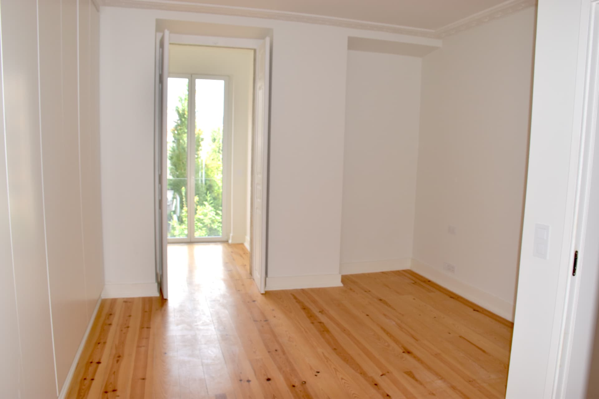 Quarto amplo com sanca trabalhada e acesso à varanda