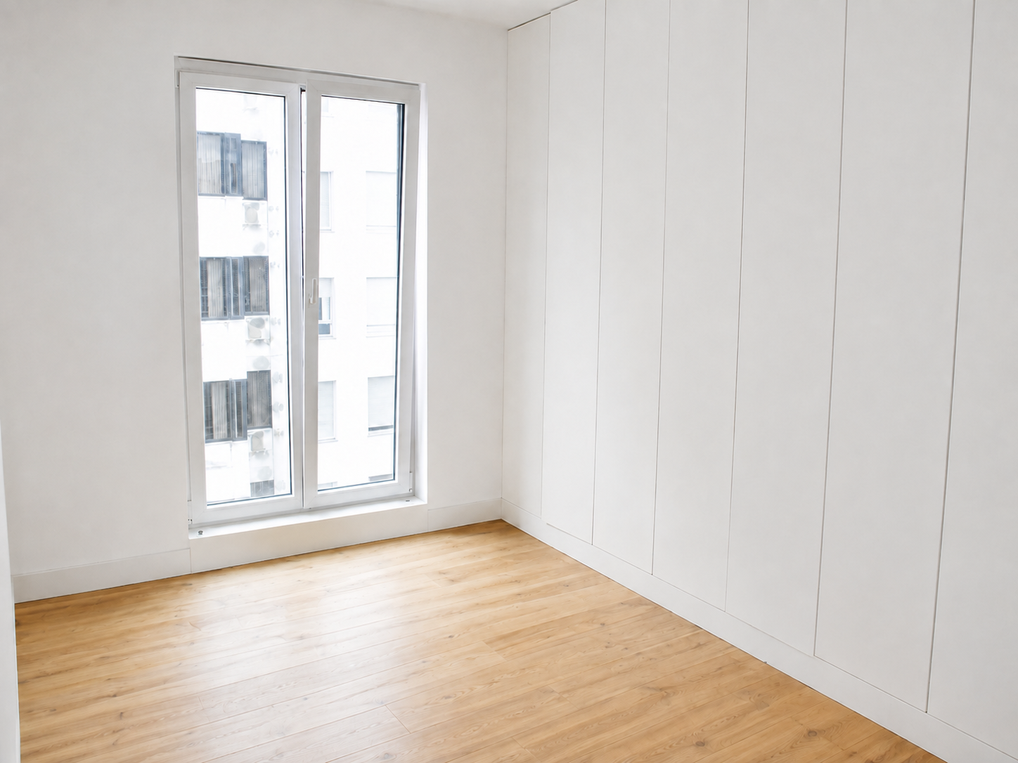 Quarto com roupeiros embutidos e janela ampla